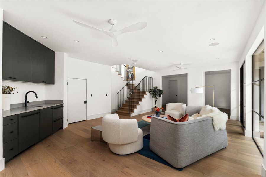 Living area with a ceiling fan, light wood-style floors, and recessed lighting