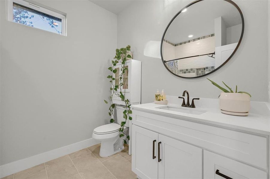 Bathroom with toilet, tile patterned flooring, and vanity