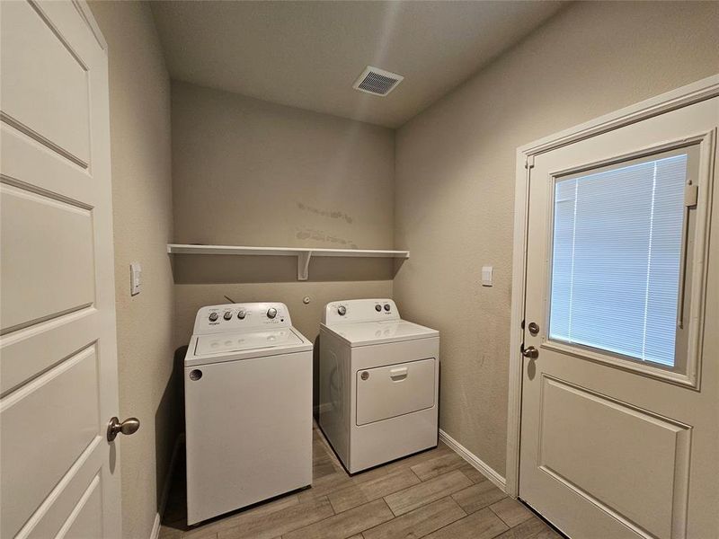 Laundry area with wood looking tile finish floors and washing machine and clothes dryer