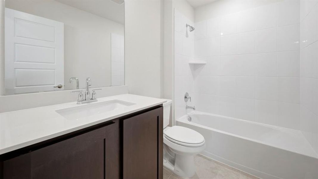 Bathroom featuring tub / shower combination, vanity, and light tile patterned floors