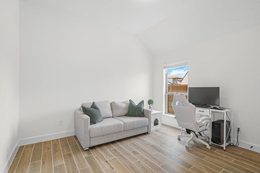 Bright and cozy secondary bedroom with wood-tile flooring, and ensuite bathroom.