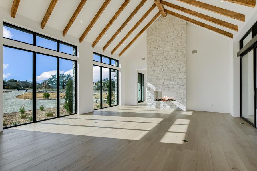 Unfurnished living room featuring a stone fireplace and hardwood / wood-style flooring