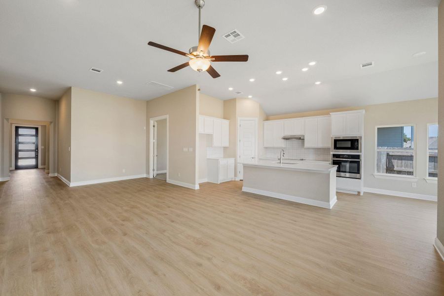 Unfurnished living room with light wood-type flooring, ceiling fan, and recessed lighting