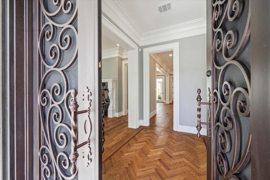 Imagine bringing your friends through these beautiful iron doors onto the herringbone wood flooring in the entry and on into your new home!