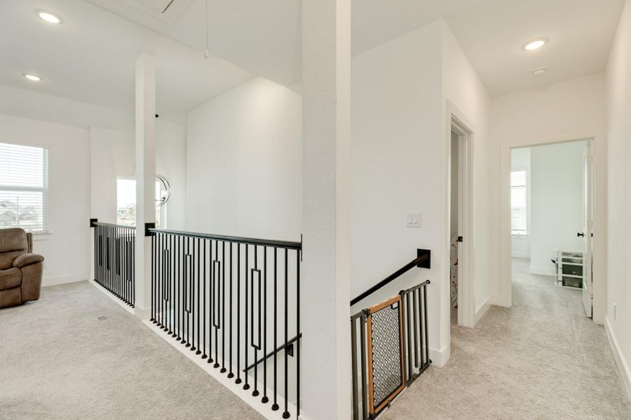 Upstairs features a versatile flex room, currently utilized as a secondary family area. This adaptable space could serve as an office or game room, boasting ample square footage and windows for abundant natural light.