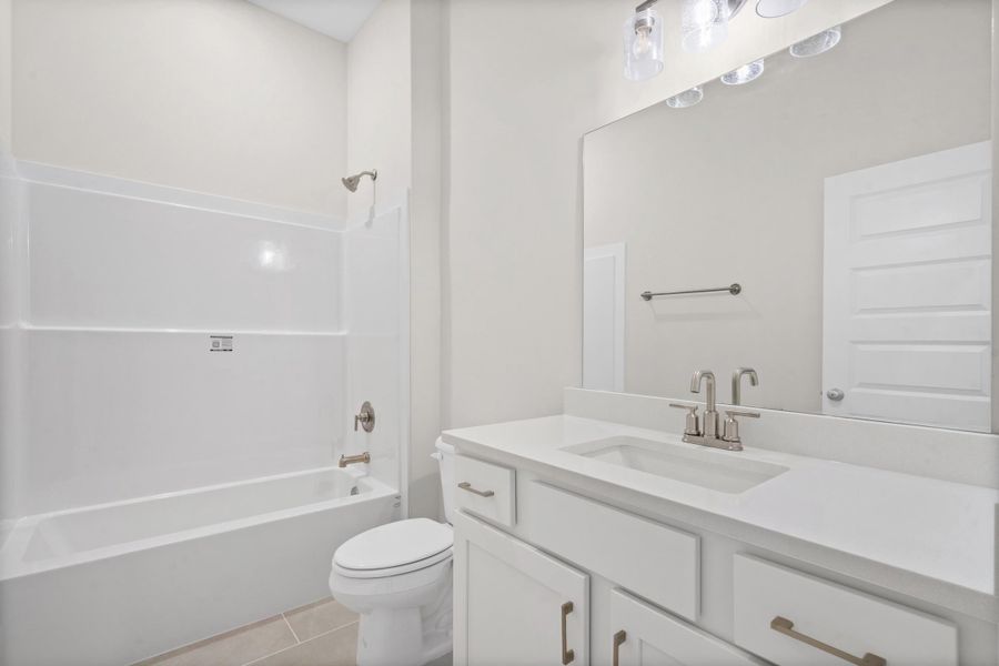 White vanity with an integrated sink, brushed nickel faucet, large mirror, and overhead vanity lighting