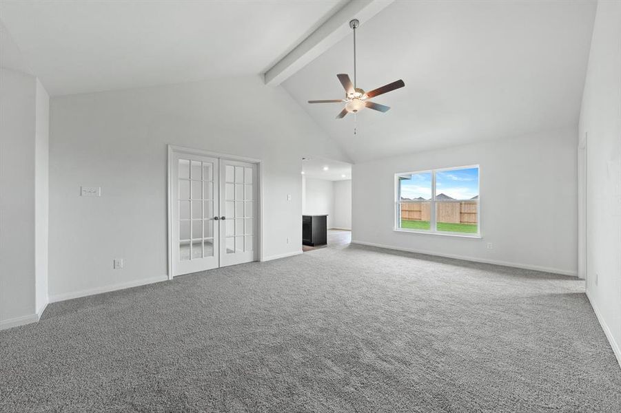 Unfurnished living room featuring beamed ceiling, carpet flooring, high vaulted ceiling, and ceiling fan