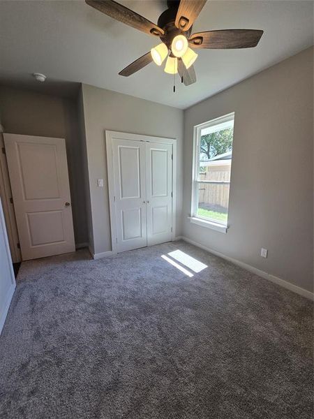 Unfurnished bedroom featuring a closet, carpet, and ceiling fan