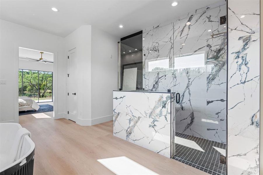 Full bath featuring ensuite bathroom, a marble finish shower, a freestanding tub, recessed lighting, and a ceiling fan