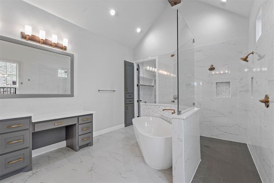 Bathroom with tile flooring, independent shower and bath, vanity, and lofted ceiling