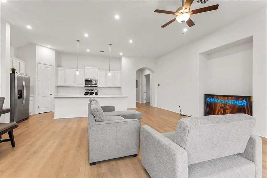 Living room featuring recessed lighting, arched walkways, light wood-type flooring, and ceiling fan Living room featuring recessed lighting, arched walkways, light wood-type flooring, and ceiling fan