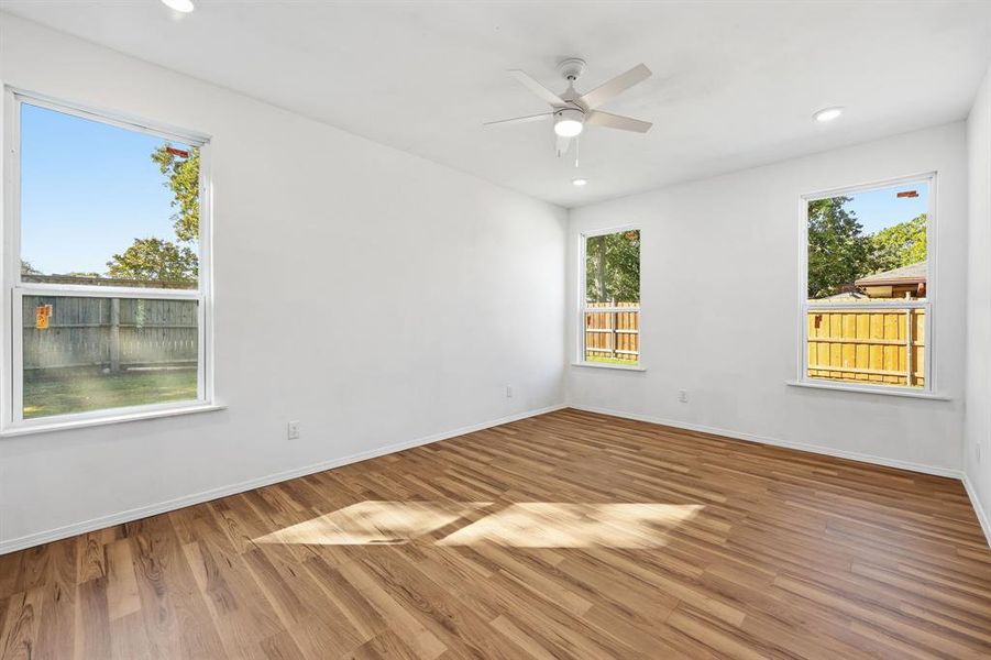 Primary bedroom featuring wood finished floors, recessed lighting, and ceiling fan