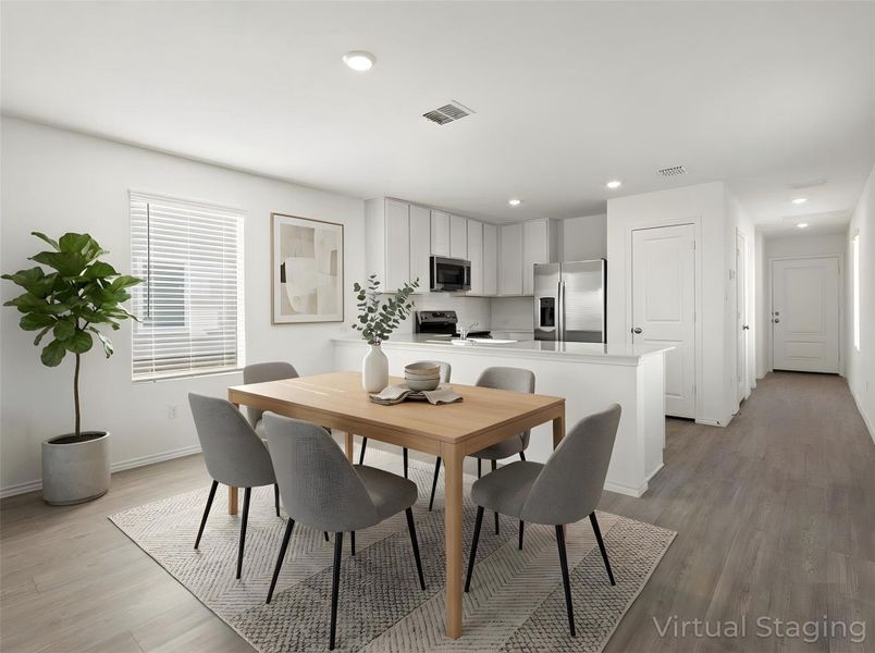 Photo has been enhanced with virtual modifications. Dining space with light wood-style floors and recessed lighting