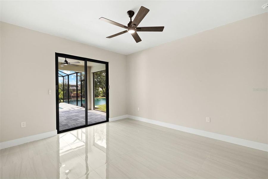 Primary bedroom - sliding doors to Lanai, view of pool and canal Primary bedroom - sliding doors to Lanai, view of pool and canal