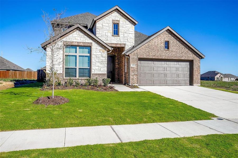 View of front of home featuring a front yard and a garage