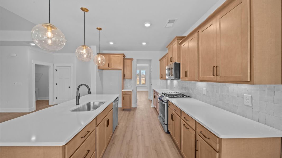 Tasteful kitchen with oversized island and stylish pendant lighting crafted to high standards