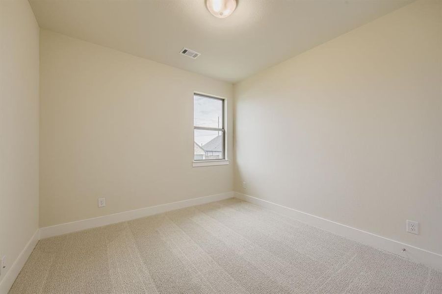 Carpeted empty room featuring baseboards