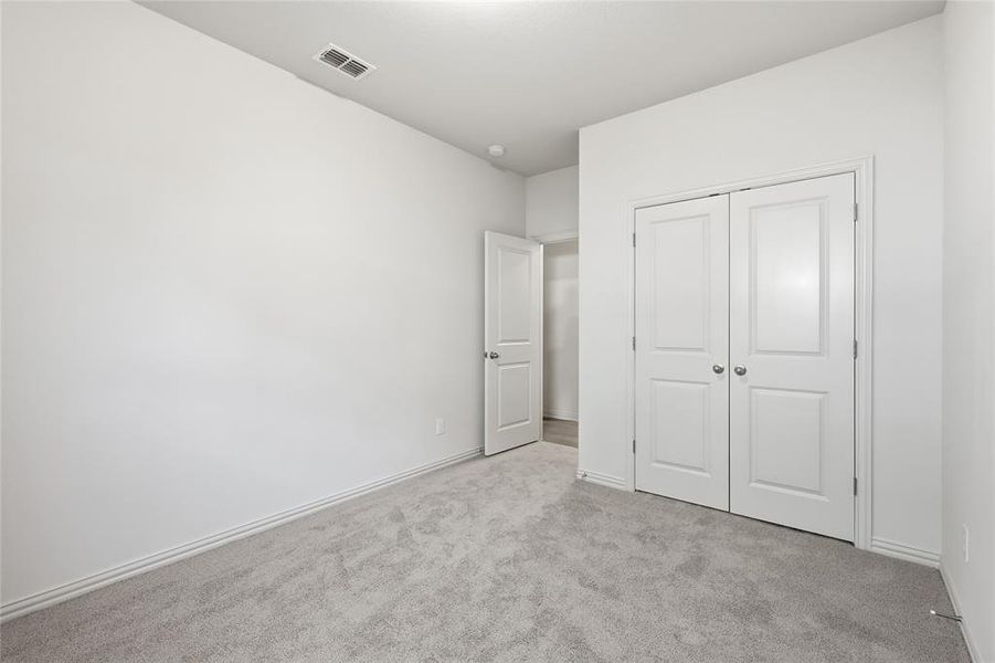 Unfurnished bedroom with carpet and a closet Unfurnished bedroom with carpet and a closet