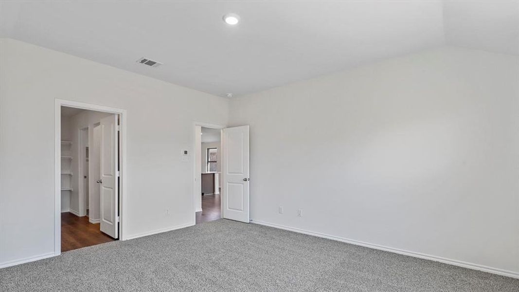 Unfurnished bedroom featuring dark carpet and baseboards Unfurnished bedroom featuring dark carpet and baseboards