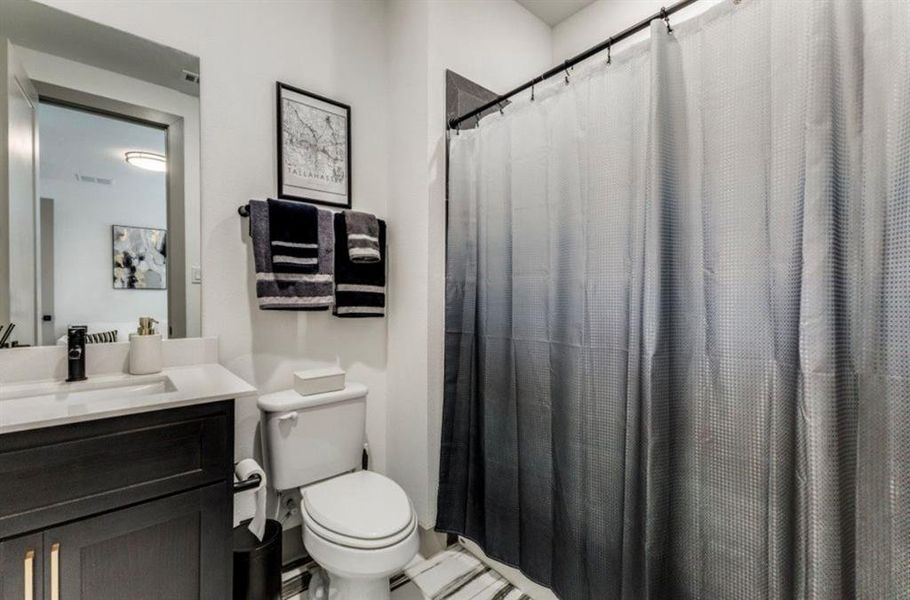 Bathroom with vanity and curtained shower