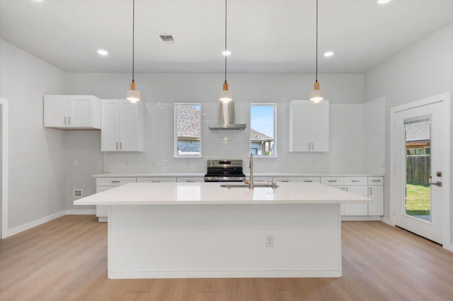 A pristine culinary space awaits with an inviting island and essential modern appliances.