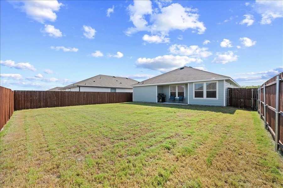 Rear view of house with a patio, a fenced backyard, and roof with shingles Rear view of house with a patio, a fenced backyard, and roof with shingles