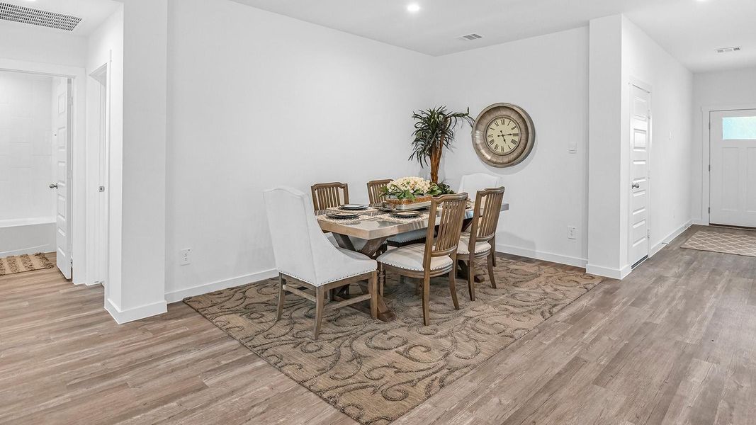 Spacious open concept dining area with vinyl wood flooring and access to the living and kitchen areas