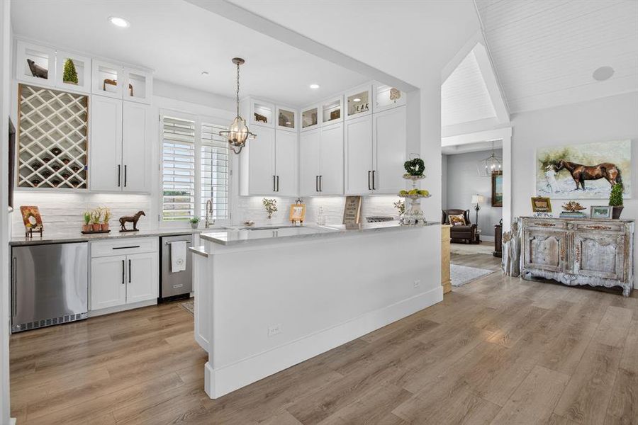 The entertainment bar has a refrigerator, ice machine, sink, wine refrigerator, and so much storage.