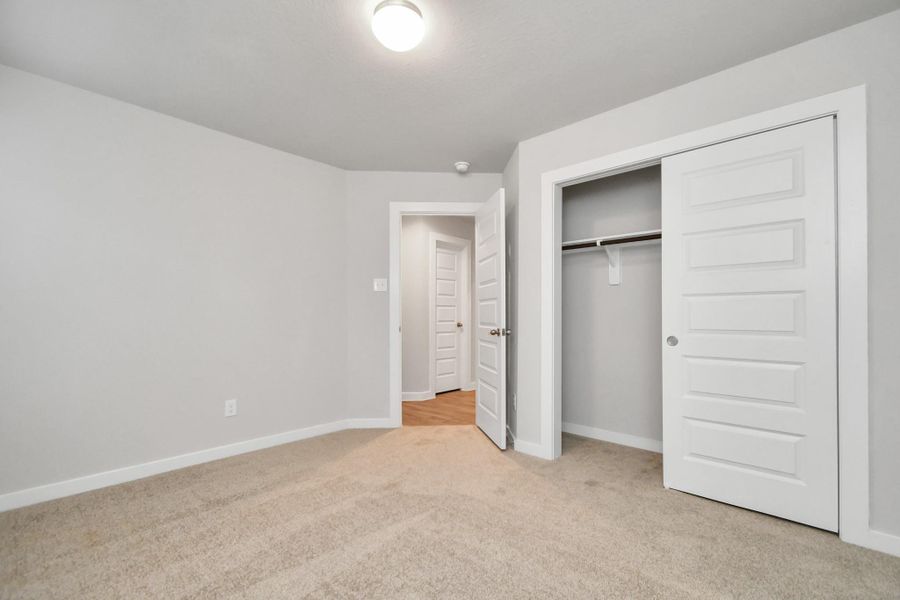 Generously sized secondary bedrooms featuring spacious closets, soft and inviting carpeting underfoot, large windows allowing plenty of natural light, and the added touch of privacy blinds for your personal retreat. Sample photo of completed home with similar floor plan. As-built interior colors and selections may vary. Generously sized secondary bedrooms featuring spacious closets, soft and inviting carpeting underfoot, large windows allowing plenty of natural light, and the added touch of privacy blinds for your personal retreat. Sample photo of completed home with similar floor plan. As-built interior colors and selections may vary.