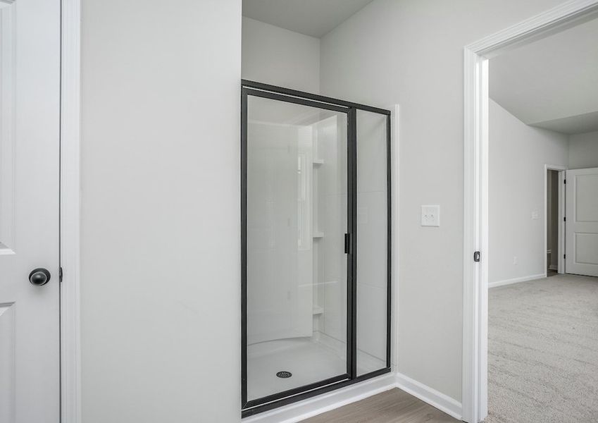 The master bathroom features a glass-enclosed shower.