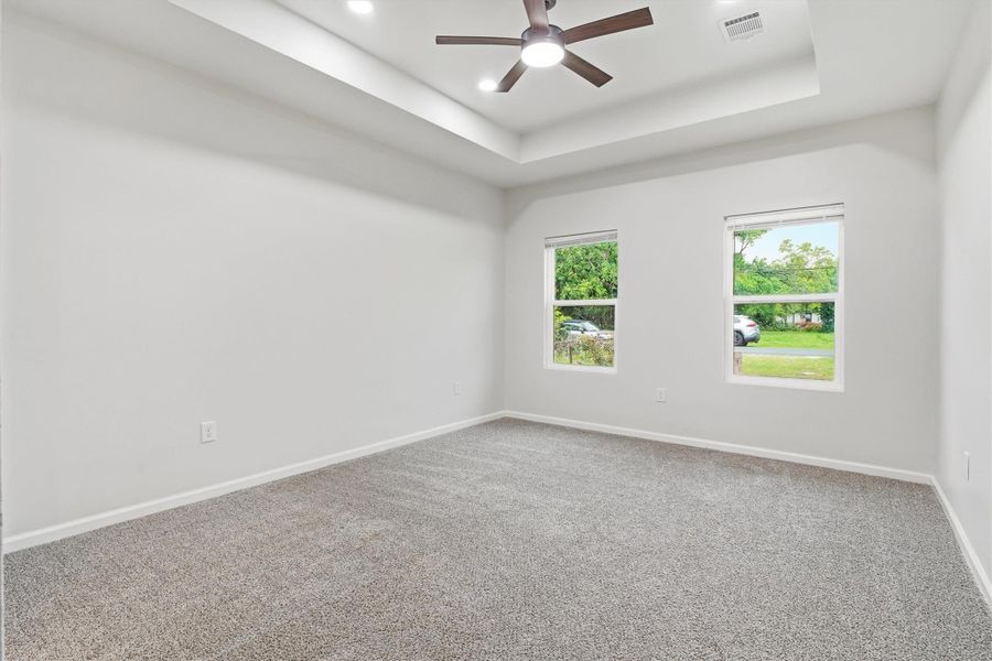 Primary bedroom with brand new carpet, paint and updated ceiling fan