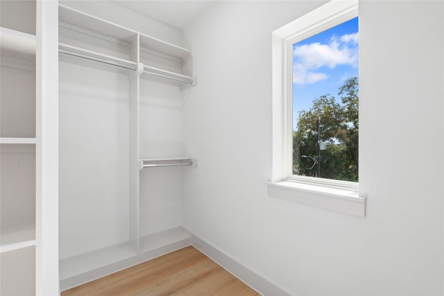 A sunlit walk-in closet, complete with a picture window for natural light & easy outfit checks. A sunlit walk-in closet, complete with a picture window for natural light & easy outfit checks.