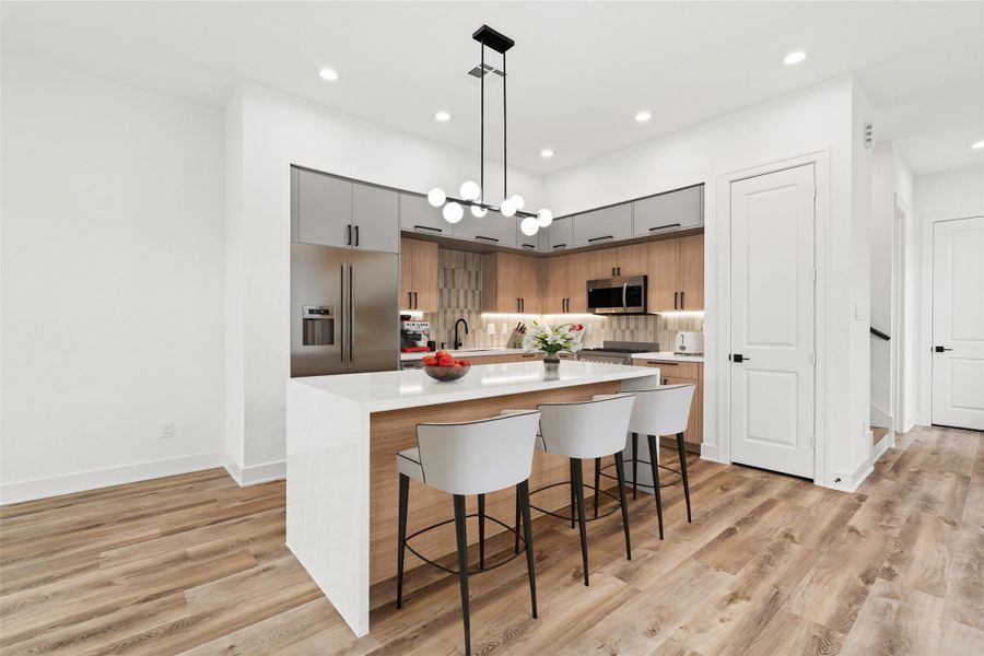 The kitchen is a true centerpiece, featuring a large island and a sleek, contemporary design that feels both stylish and functional. The open layout and modern lighting make it perfect for entertaining or everyday living.