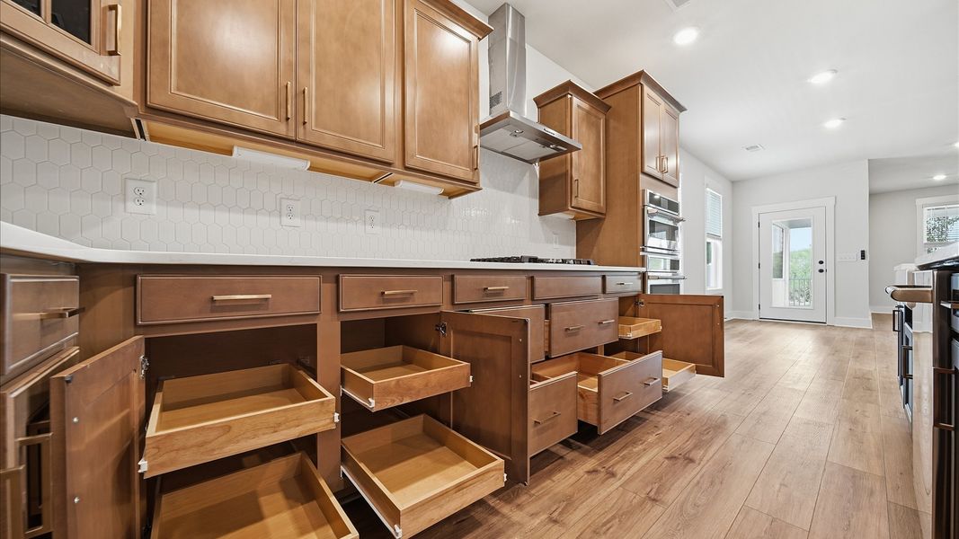 Open-concept kitchen designed to maximize both efficiency and entertaining potential by DRB Homes