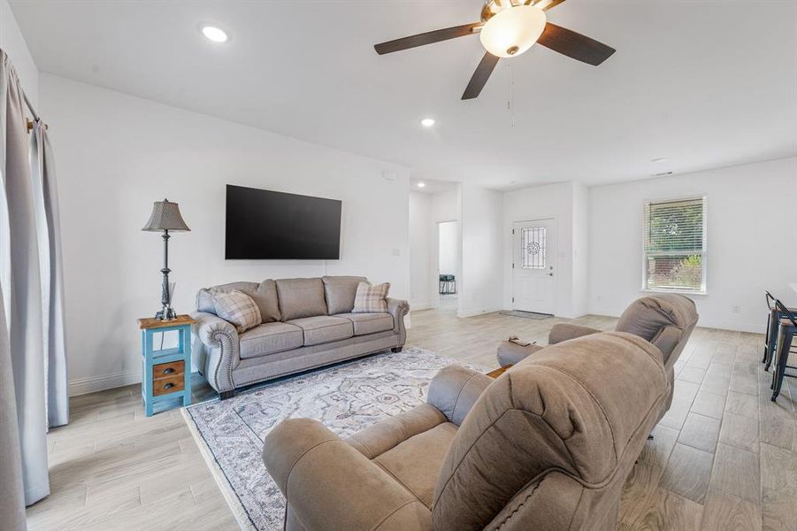 Living room with recessed lighting, light wood-style floors, and a ceiling fan