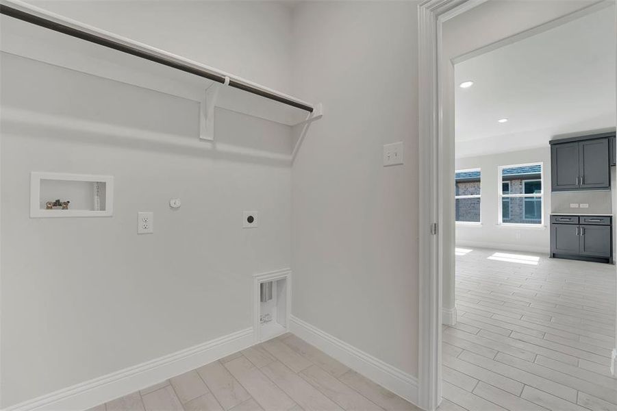 Washroom with hookup for a gas dryer, laundry area, washer hookup, baseboards, and electric dryer hookup