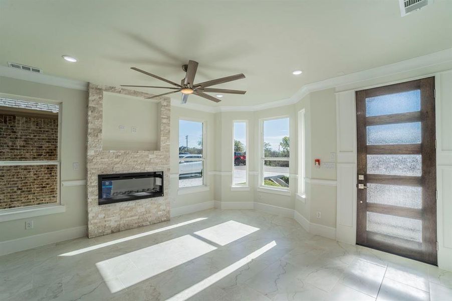 Unfurnished living room featuring a ceiling fan, marble tiled floors, a fireplace, crown molding, and recessed lighting Unfurnished living room featuring a ceiling fan, marble tiled floors, a fireplace, crown molding, and recessed lighting