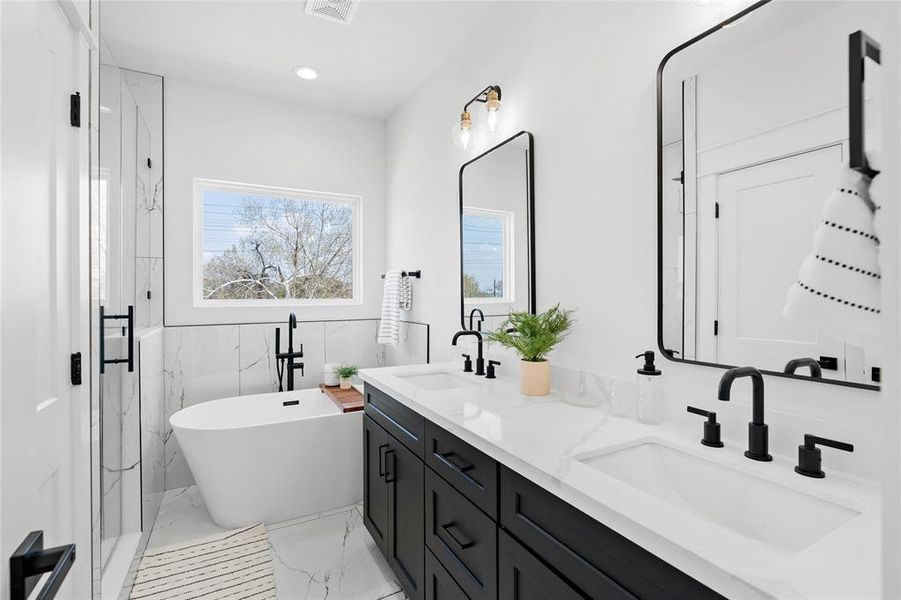 Indulge in the luxury of a stunning sleek design bathroom featuring an oversized quartz countertop with dual sinks, alongside an oversized frameless shower and standalone tub, creating a serene oasis for relaxation and rejuvenation.