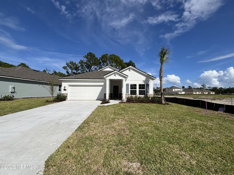 Front exterior of a new home in The Magnolia Series at Reserve East, Flagler Beach, FL, highlighting curb appeal (Image 18).