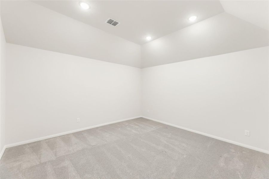 Empty room with gray carpet, white walls, and recessed ceiling lights