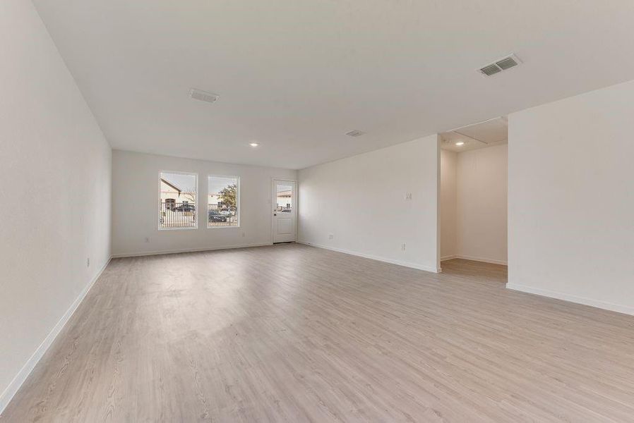 Unfurnished room featuring light wood-type flooring, visible vents, and baseboards