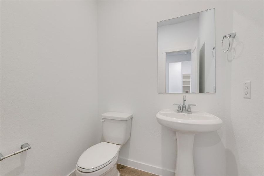 Bathroom with hardwood / wood-style floors, toilet, and sink