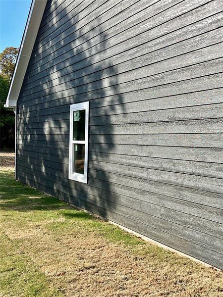 View of side of home with a lawn