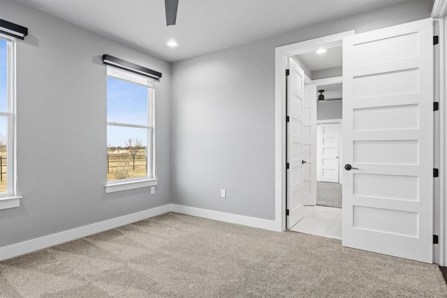 Unfurnished bedroom with light colored carpet, ceiling fan, ensuite bathroom, and recessed lighting