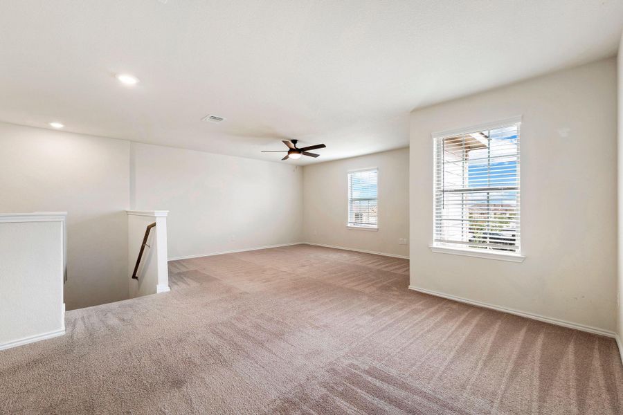 A spacious upstairs loft provides flexible living space with carpeted flooring and abundant natural light. A spacious upstairs loft provides flexible living space with carpeted flooring and abundant natural light.