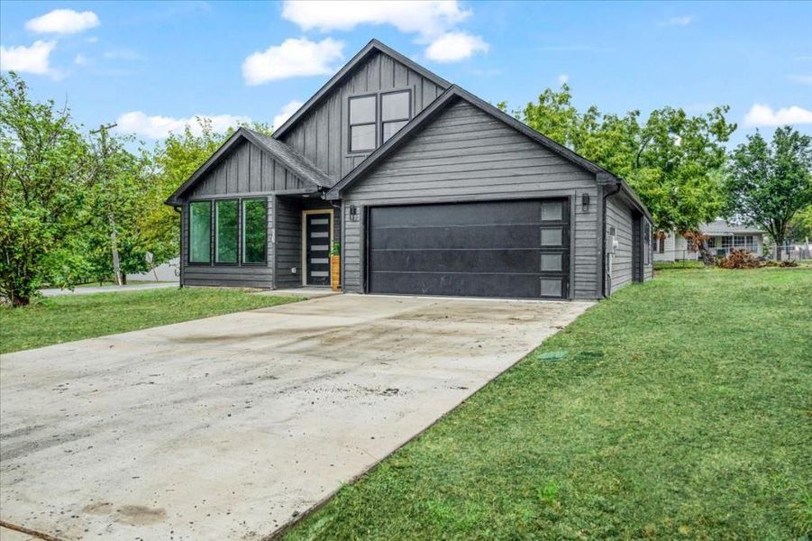 View of front facade with a front lawn and a garage