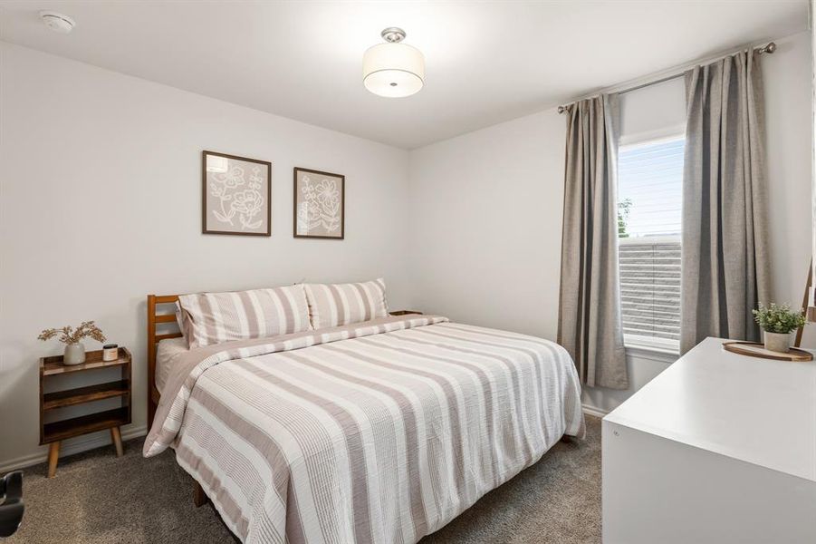 This room features a window with blinds and drapes, a light-colored carpet, and a ceiling light fixture This room features a window with blinds and drapes, a light-colored carpet, and a ceiling light fixture