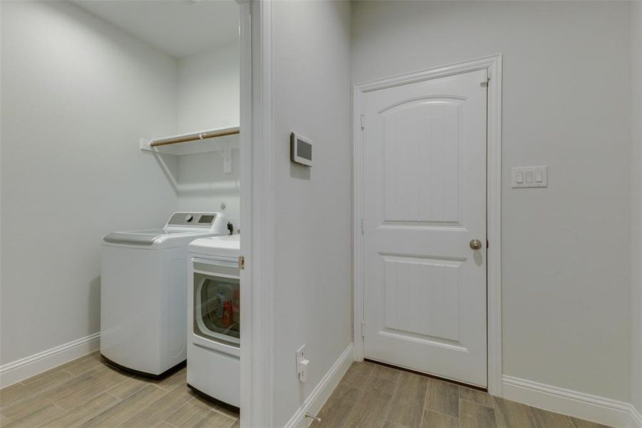 Laundry area featuring light hardwood / wood-style floors and washer and clothes dryer