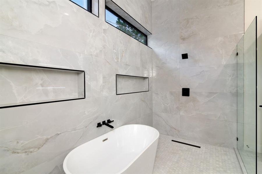 Bathroom featuring separate shower and tub and tile walls