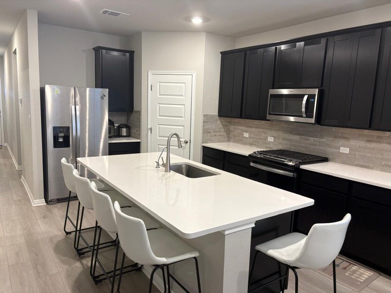 Culinary delights await in this sleek kitchen featuring a generous island and modern fixtures.